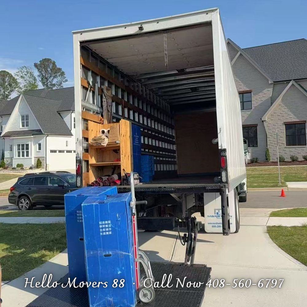 A Hello Movers truck parked at a house, with dollies and moving bins